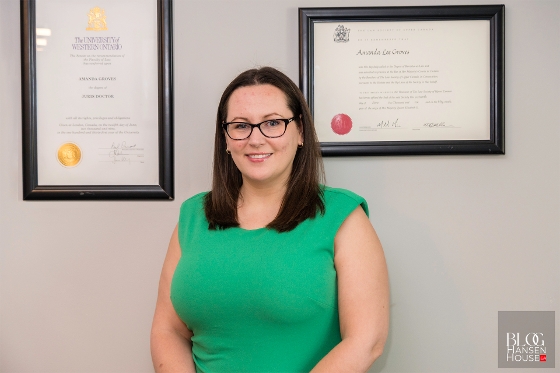 Amanda Groves JD with diplomas on the wall