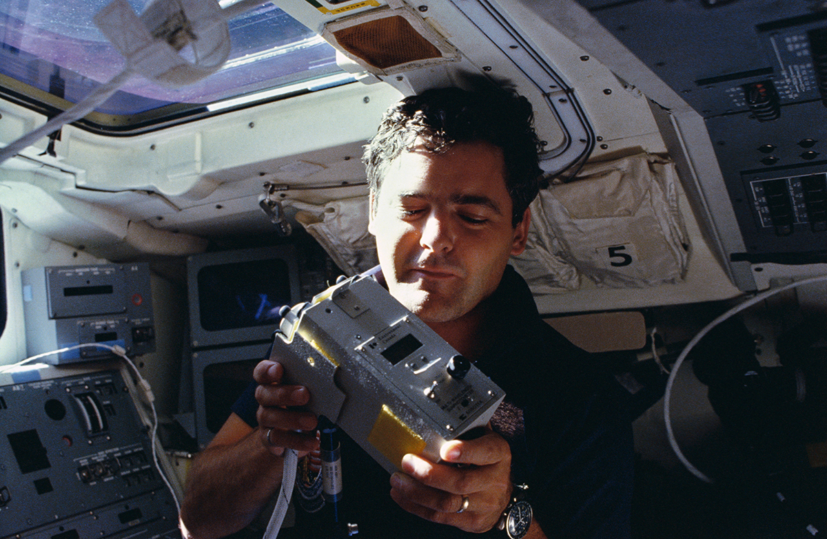 Payload specialist Marc Garneau displays Canadian made Sunphotometer, part of a package of experiments (NASA)